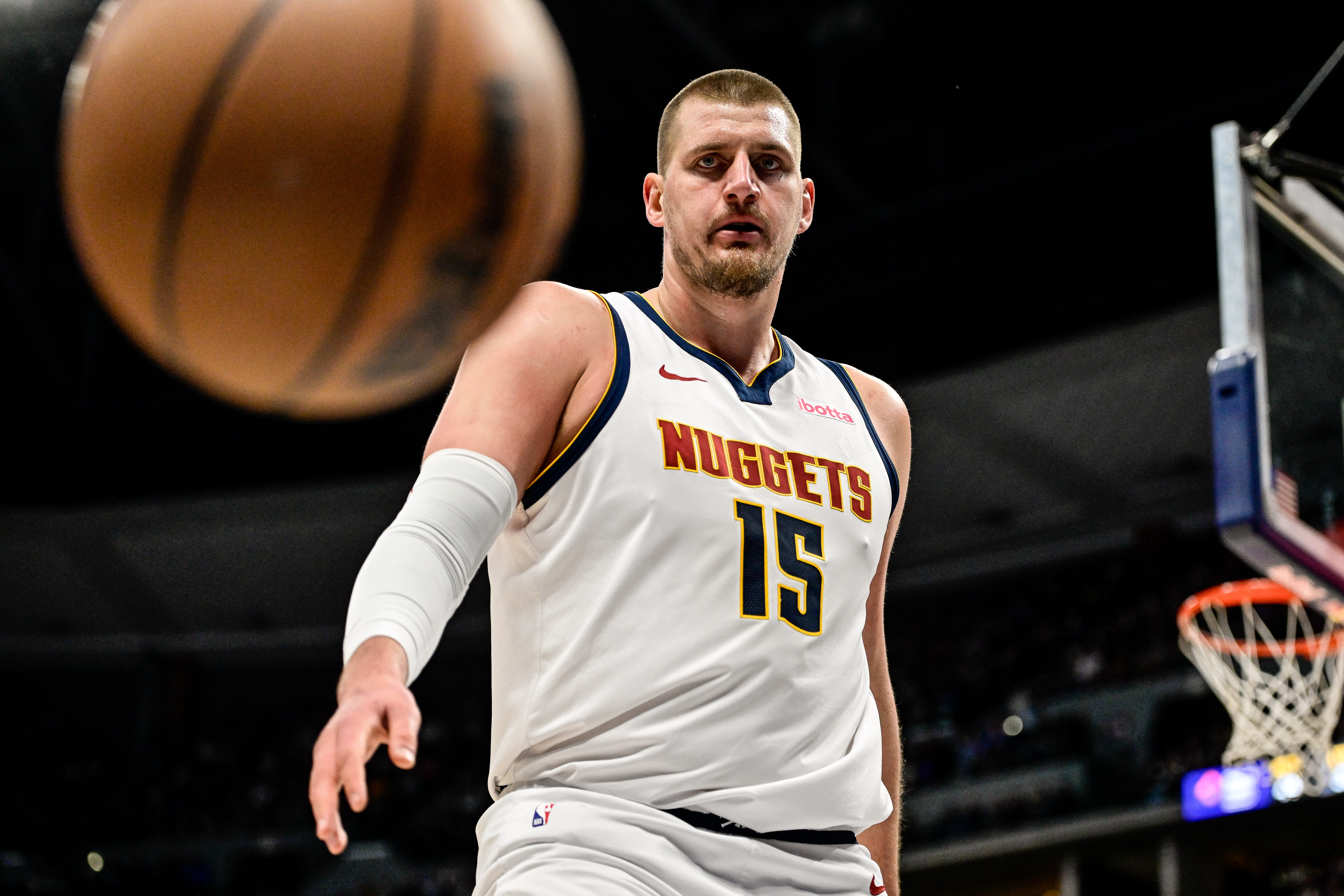 Nikola Jokic tosses a ball. 