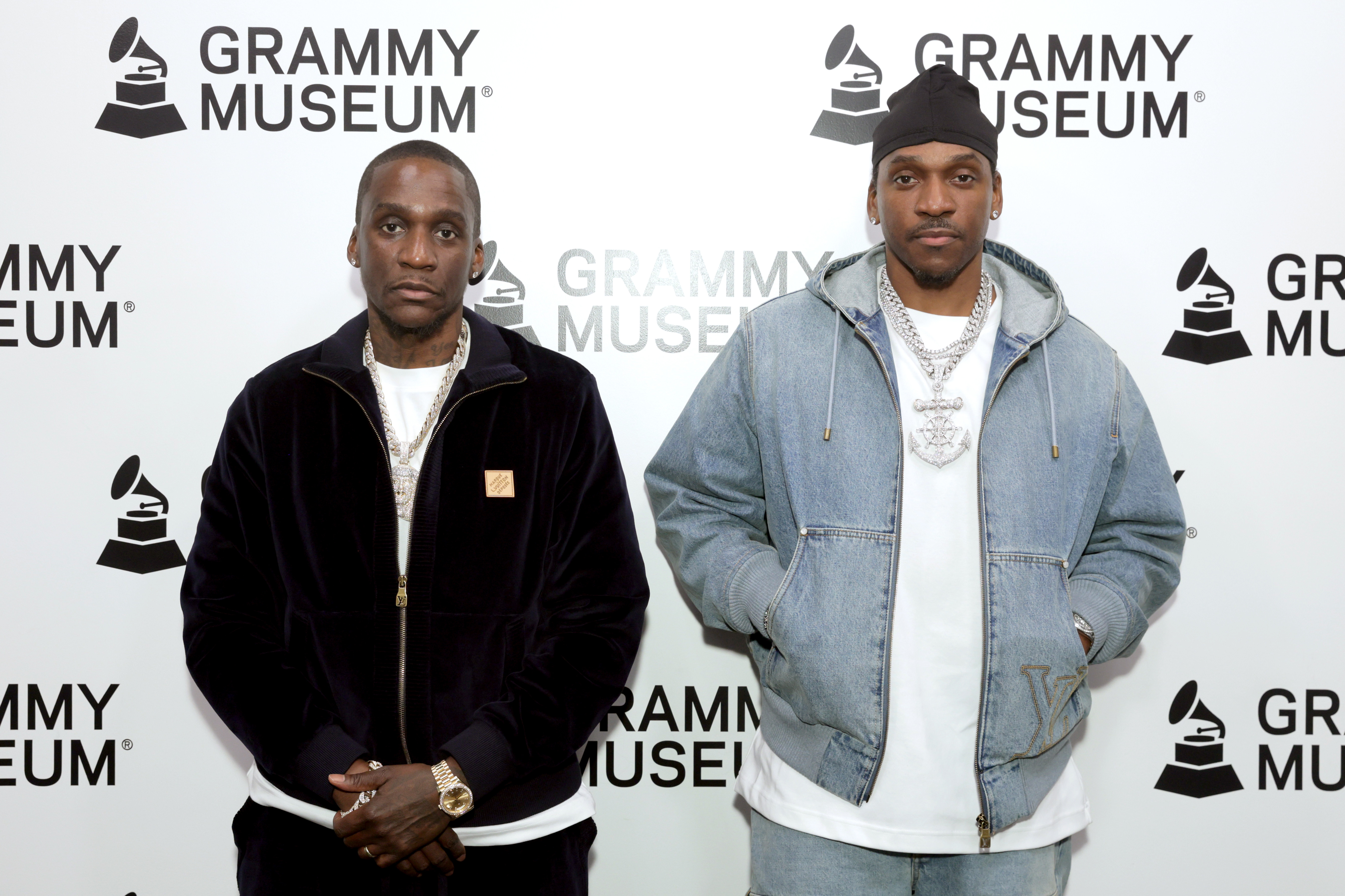 Clipse at a Grammy Museum event, wearing casual outfits with jewelry, posing in front of a branded backdrop. They are favorites to win a Best Rap Album Grammy. 