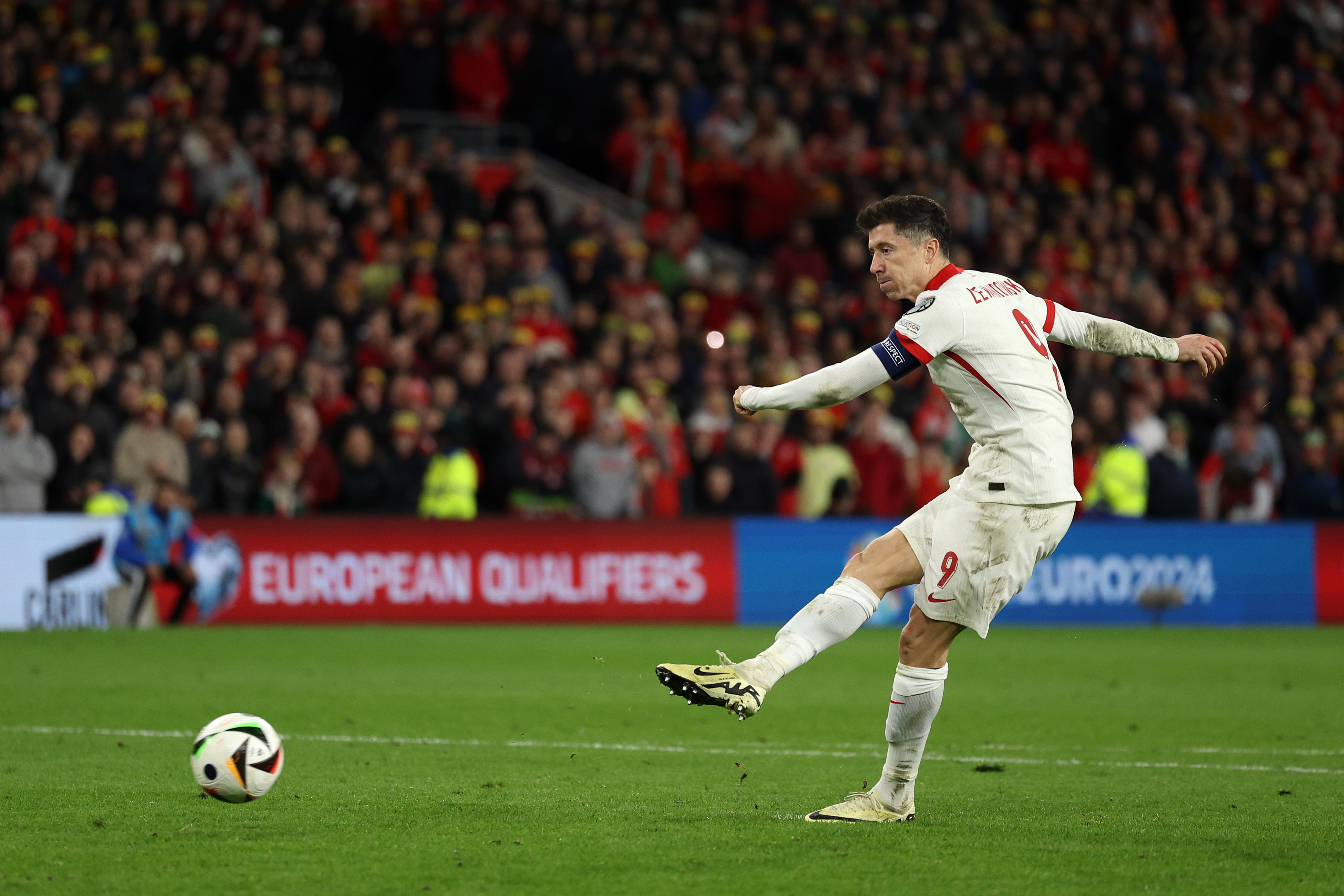 Robert Lewandowski scores on a penalty kick during a shootout during the Poland-Wales Euro 2024 playoff. 